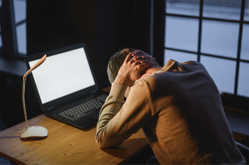 Young businessman experiencing digital burnout during a virtual event