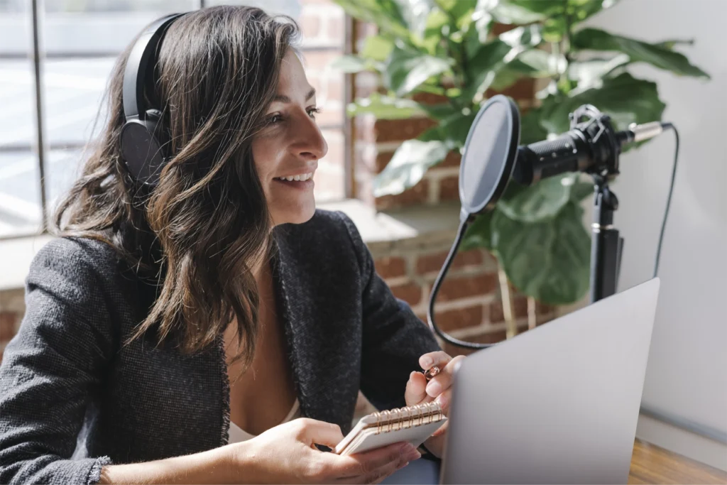 A woman in headphones sitting at a microphone to present on a GlobalMeet virtual event